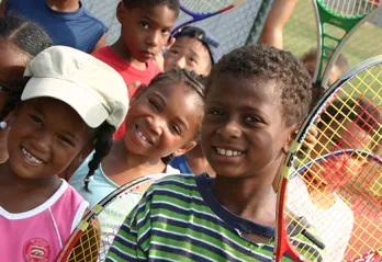 Smiling kids with tennis rackets