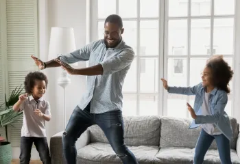 a father dancing with his 2 younger children