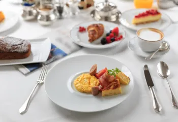 breakfast plated at a table with coffee and pastries
