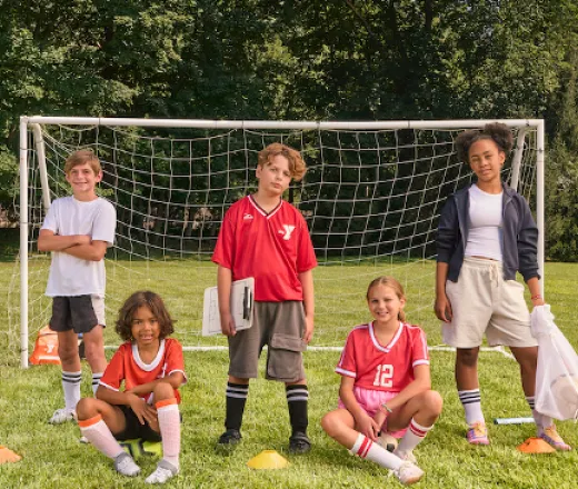 kids posing in front of a soccer goal