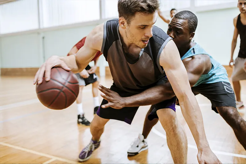 Men playing basketball in gym