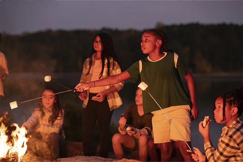 Roasting marshmallows around campfire