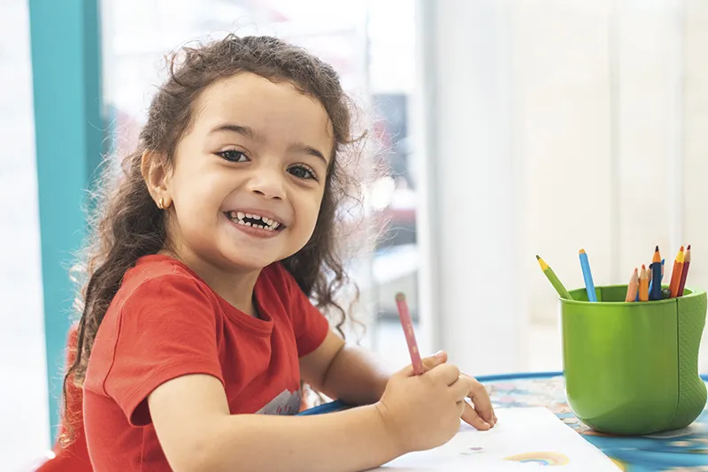 Smiling girl coloring