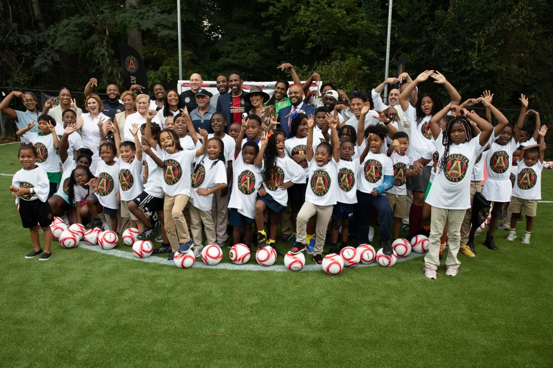 Group of kids celebrating the new soccer pitch at the Andrew & Walter Family YMCA