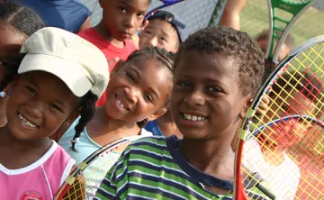 Smiling kids with tennis rackets